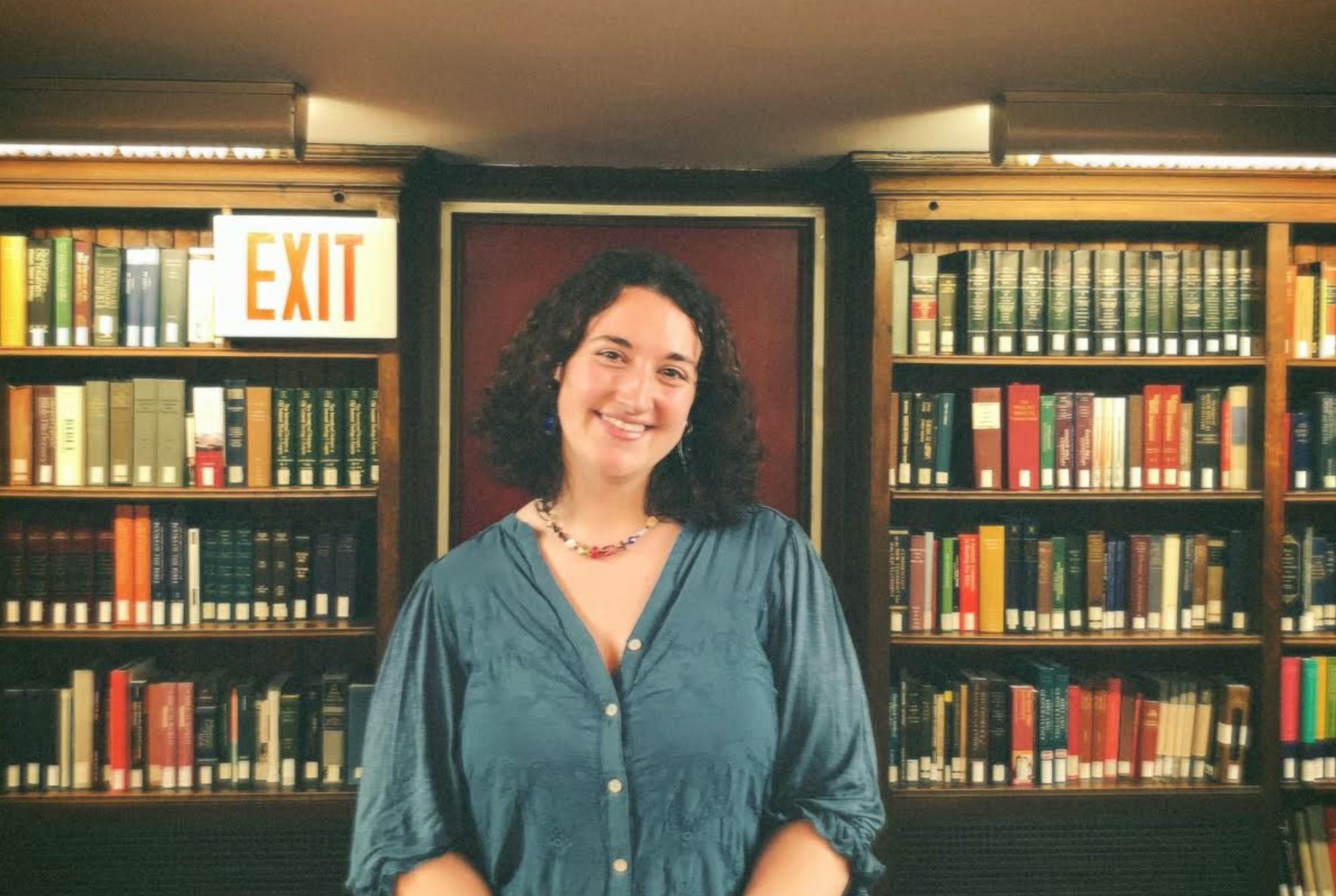 Headshot of student Haley Planicka smiling in front of bookshelves